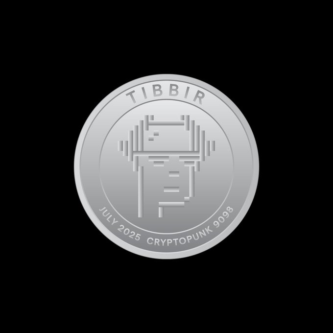 A silver commemorative coin on a black background featuring a pixelated character design with the text "TIBBIR," "JULY 2025," and "CRYPTOPUNK 9098" — referencing the Ribbit Capital-backed Bitcoin project TIBBIR (likely associated with the well-known CryptoPunk #9098 NFT).