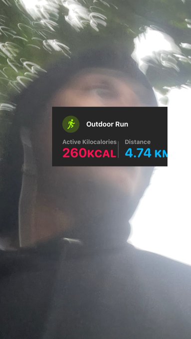 A blurry selfie of a person outdoors with an overlaid workout widget showing 'Outdoor Run' with 260 KCAL active calories and 4.74 km distance.