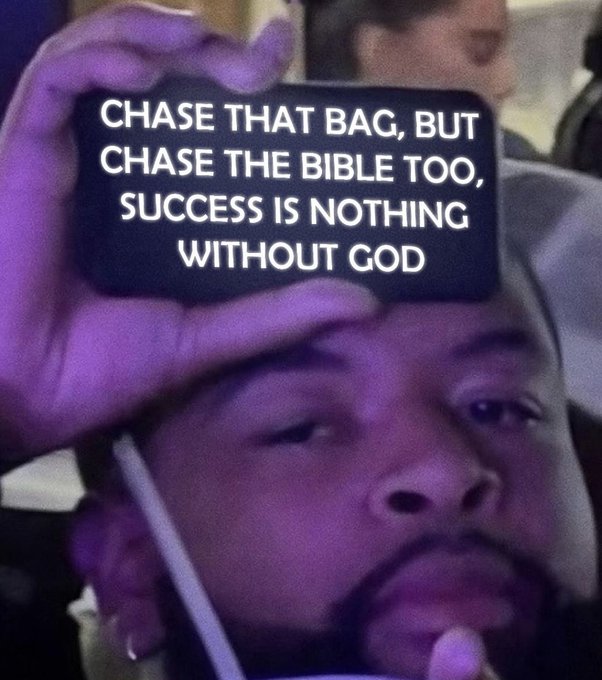 A close-up of a person holding up a black phone case that reads, 'CHASE THAT BAG, BUT CHASE THE BIBLE TOO, SUCCESS IS NOTHING WITHOUT GOD.'