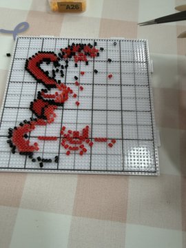 A partially completed perler bead art piece on a grid board depicts the word "Liquidation" in red beads alongside a skull-and-crossbones symbol, with the text "A20" visible on a bottle cap in the background, visually representing the trader's lament about portfolio losses surpassing even the pain of liquidation.