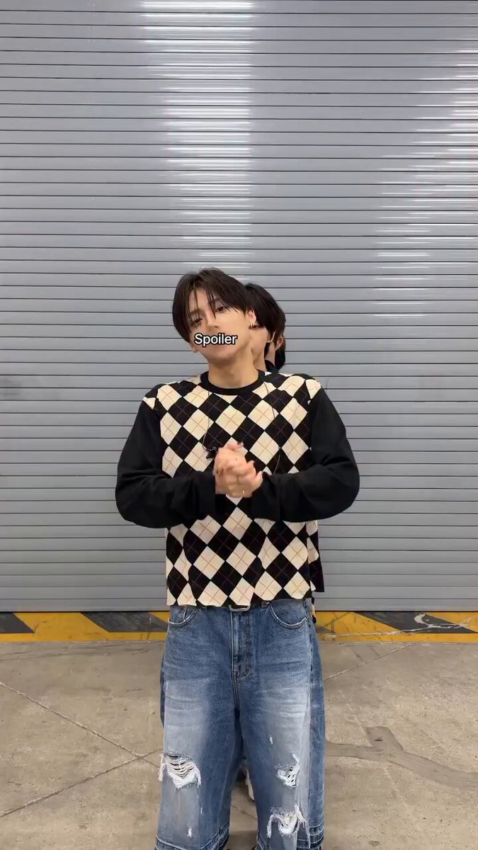 The image features a young man wearing a black and white sweater with a checkered pattern, blue jeans, and ripped shorts. He has his hands together and appears to be posing for a photo or video. The caption of the image reads "260612 ald1.official update spo drive one #ALPHADRIVEONE #ALD1 #알파드라이브원".