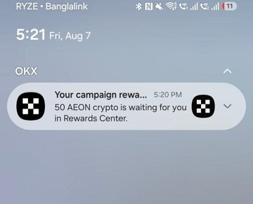 An Android phone screenshot showing a notification from OKX app at 5:21 PM stating 'Your campaign reward: 50 AEON crypto is waiting for you in Rewards Center' on a RYZ•Bangalink carrier connection.