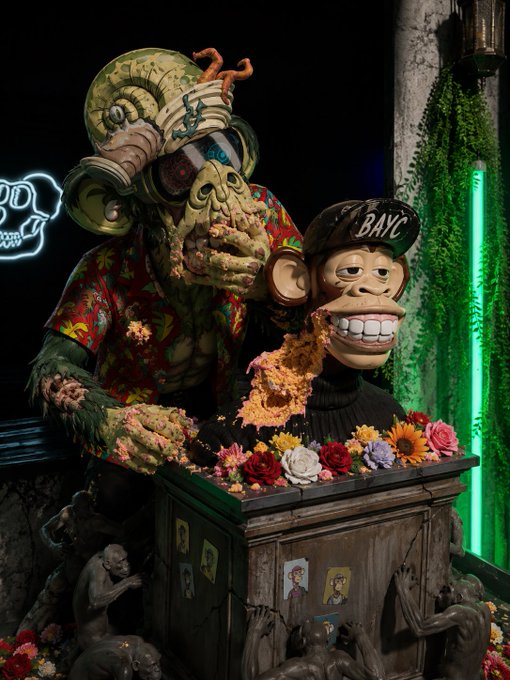 A creepy scene features a green zombie-like creature and a monkey puppet wearing a hat labeled 'BAYC,' surrounded by flowers and reaching hands emerging from below.