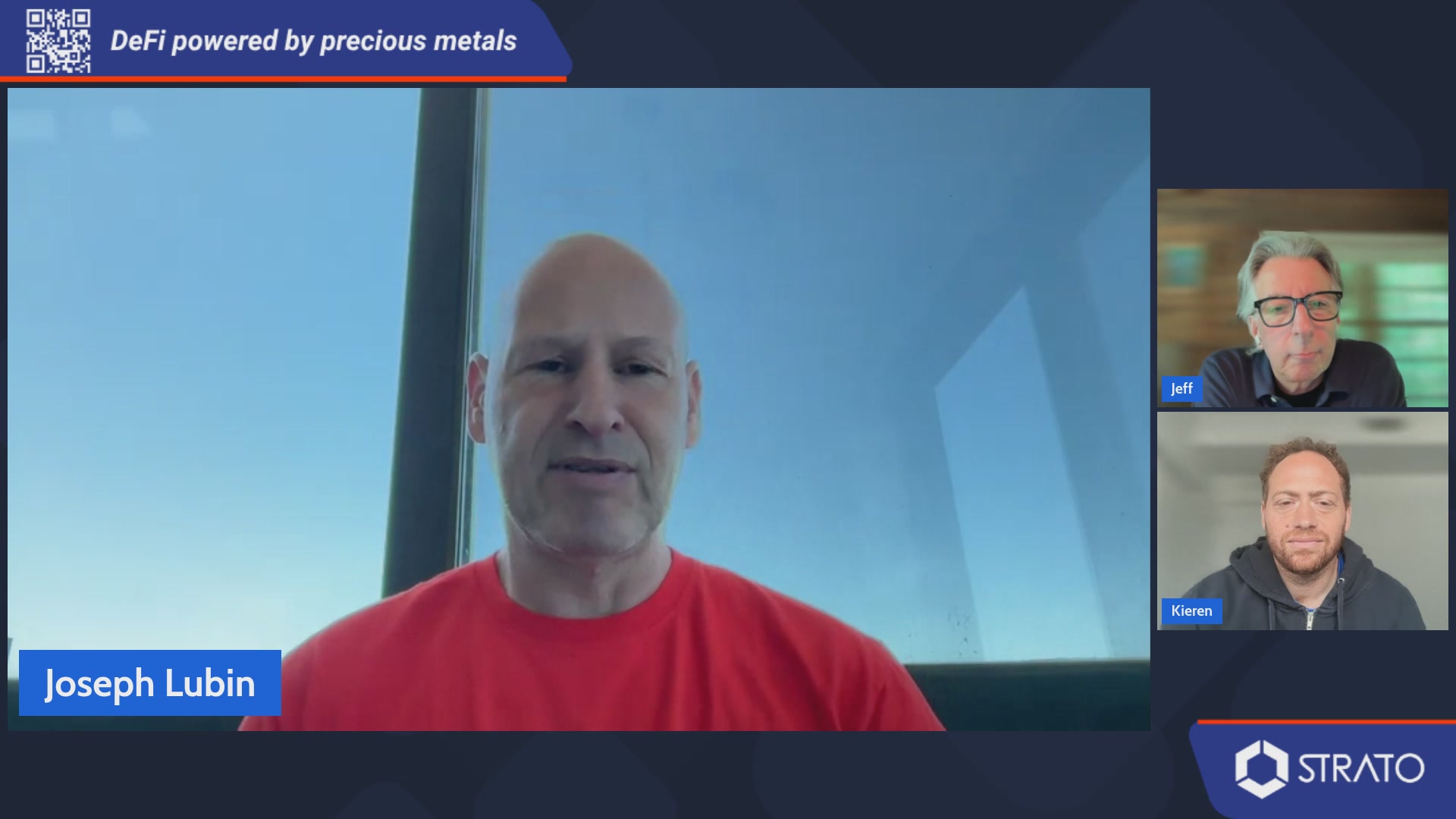 The image shows three men sitting behind a computer screen during a video conference call with a blue background. One of them is wearing a red shirt while another man has a black jacket on. The third person, who appears to be Joe Lubin, is also present in the frame. They are all looking at the camera and seem engaged in the discussion taking place on the screen.