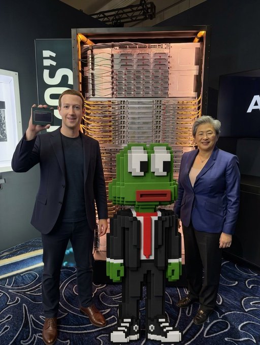 A man and a woman stand on either side of a green LEGO-style figure wearing a black suit and red tie, with the man holding up a chip in front of what appears to be server equipment, possibly at a tech event.