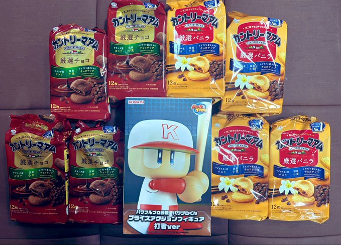 A display of Japanese 'Country Ma'am' cookie packages (chocolate and vanilla flavors) arranged around a Konami baseball video game featuring a character with a 'K' cap holding a bat.