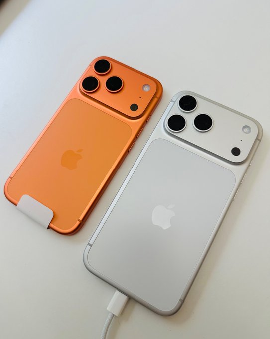 iphone cases in orange and white, with a black charging cable plugged into the case for charging.