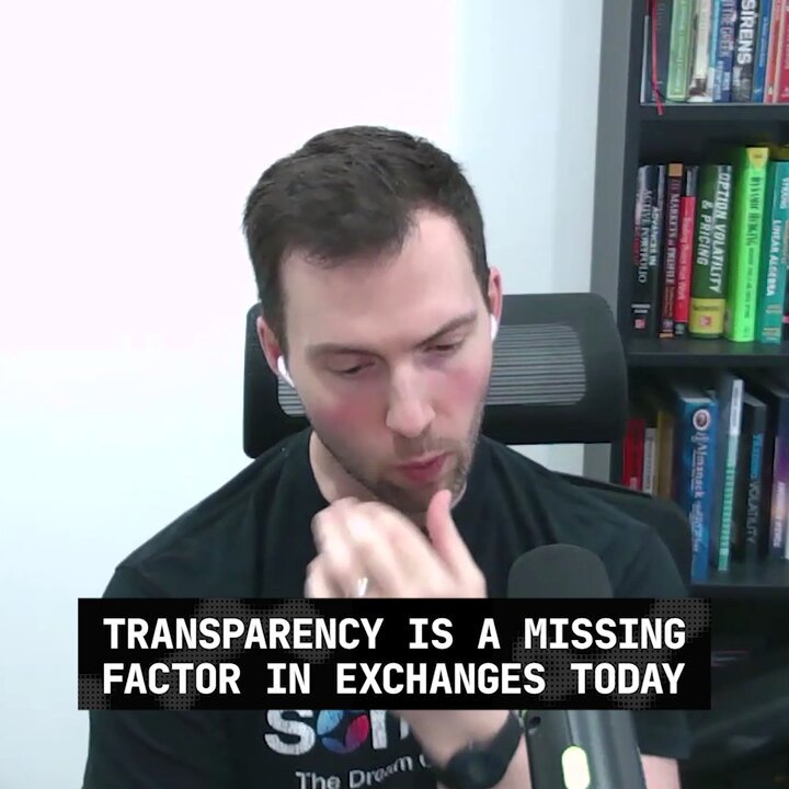 The image features a man sitting at a desk with a microphone, wearing a black shirt. The background of the image shows a bookshelf filled with various books. There are also two texts present in the image - one text reads "Transparency is a missing factor in exchanges today", and another text states "@Somnia_Network & @dreamDEXSomnia come in for the future". These texts seem to be related to the man sitting at the desk, possibly discussing the importance of transparency or the role of the network in exchanging information.