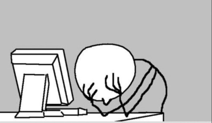 A simple black and white line drawing shows a person with a round head face-down on a desk with their head in their hands in frustration or exhaustion, next to a computer monitor and keyboard.