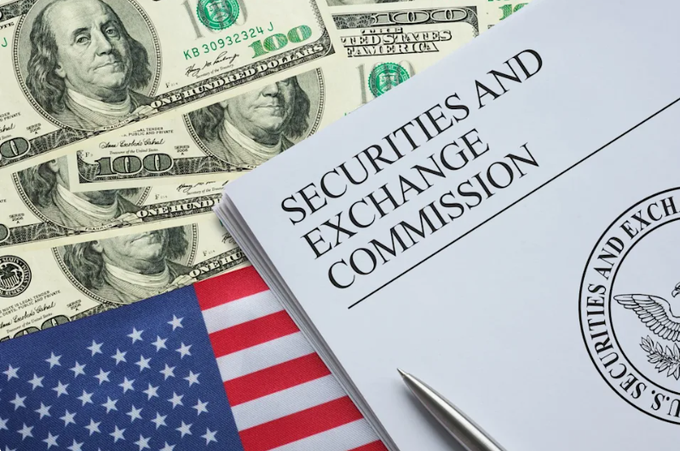 A document titled "SECURITIES AND EXCHANGE COMMISSION" rests on a bed of $100 bills beside an American flag, visually representing the SEC's role in regulating financial assets, including the new joint guidance with the CFTC on classifying crypto assets under federal securities laws.