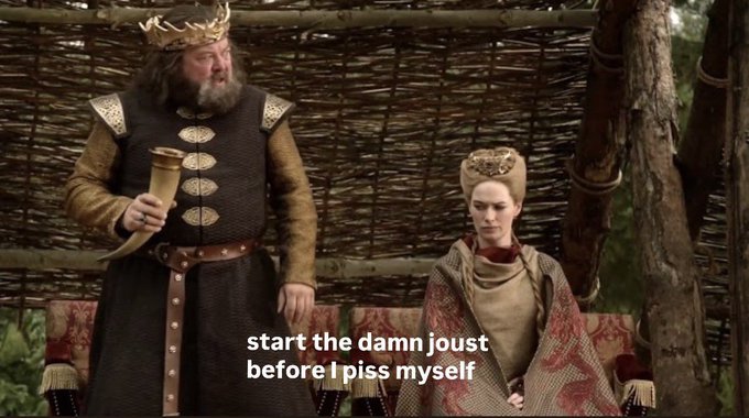 A scene from Game of Thrones showing King Robert Baratheon and Cersei Lannister seated, with overlaid text reading 'start the damn joust before I piss myself'.