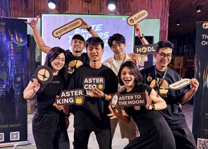 A group of six people pose at an "ASTERO" branded event, holding signs that read "ASTER KING", "ASTER CEO", "ASTER TO THE MOON!", "HODL", and "Bullish".