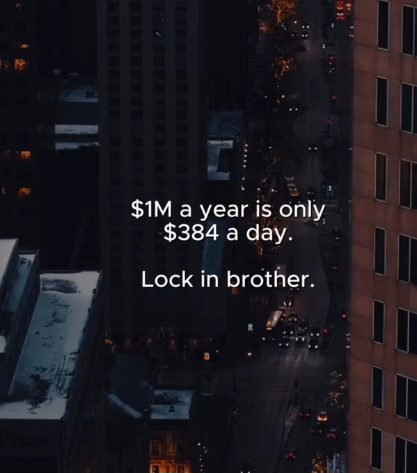 A nighttime aerial view of a city street lined with illuminated skyscrapers and traffic, overlaid with the motivational text "$1M a year is only $384 a day. Lock in brother." The urban, high-rise backdrop reinforces the financial ambition of the message, visually pairing the pursuit of wealth with the energy of a bustling downtown.