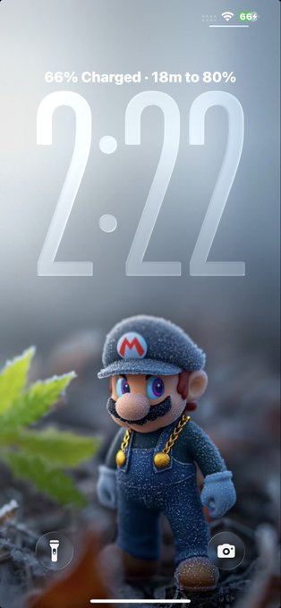 An iPhone lock screen showing the time 2:22, with a 3D-rendered Mario figurine wearing a blue cap with an 'M' logo and overalls as the wallpaper, along with a 66% charged notification.