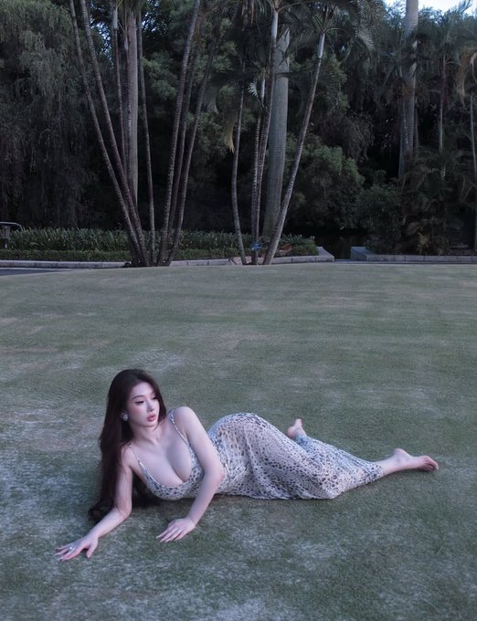 A woman in a flowing dress reclines on a lush green lawn framed by tall palm trees, evoking a tranquil, poetic scene that pairs with the post's reference to the "Tuibeitu prophecy" and the bullish arrival of the ox in relation to Bitcoin and Ethereum.