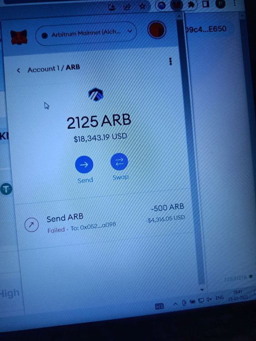 A photograph of a computer monitor displaying a MetaMask wallet on the Arbitrum Mainnet showing a balance of 2125 ARB ($18,343.19 USD) with a failed transaction of -500 ARB to address 0x052...a098.
