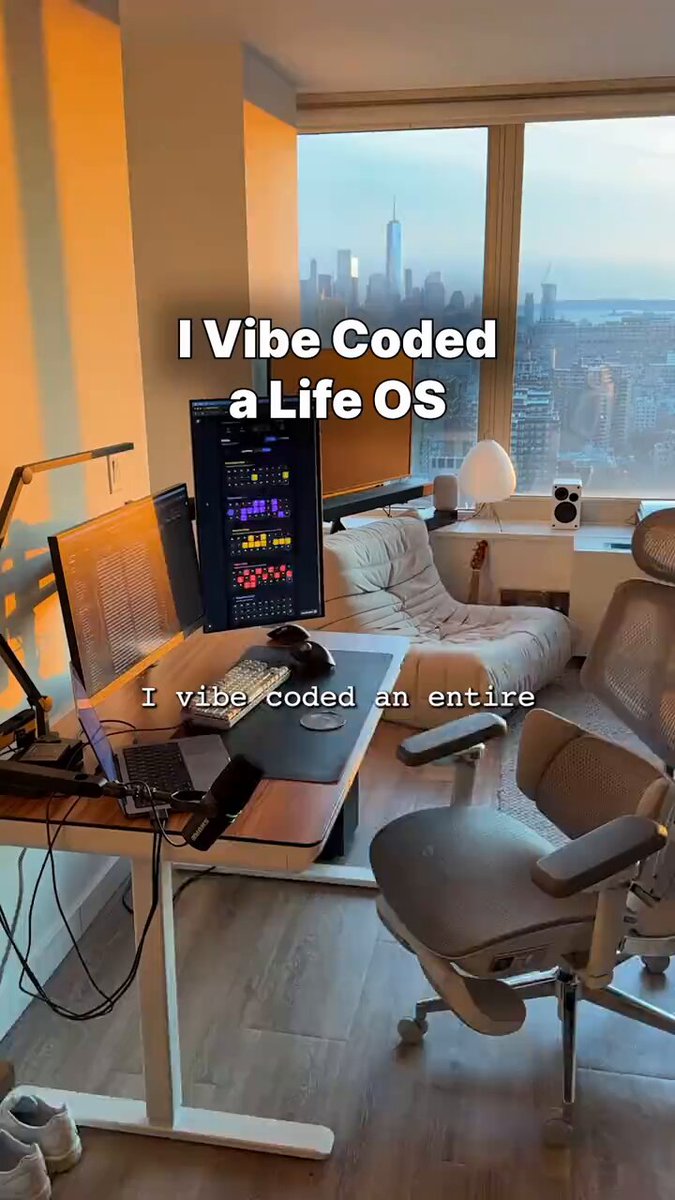 The image shows an office space with a desk featuring two computer monitors, one of which has a code written on it. The desk also has a chair placed next to it. A window can be seen behind the desk, providing natural light for the workspace. On the wall above the desk is a poster that reads "I VIBE CODED A LIFE OS". In addition to this, there are 47 Notion pages that have been replaced with 3-hour automation agency services and a spreadsheet that crashes every Monday. The office space also contains various other items such as a mouse, keyboard, and a cup on the desk.