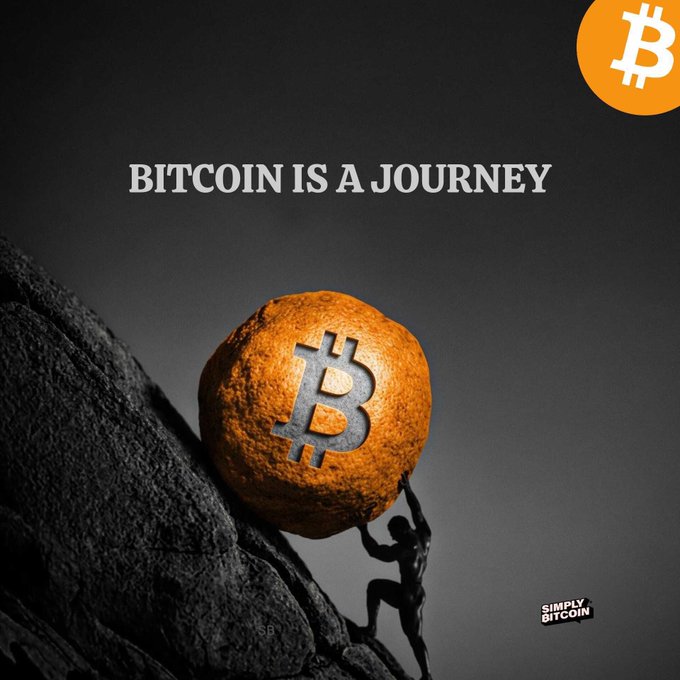 The image features an orange coin with a man holding it up against a black background, which appears to be a mountain or cliff face. Below the coin, there's text that reads "Bitcoin is a journey", suggesting that Bitcoin has been around for quite some time and has evolved over the years. The coin itself seems to symbolize the historical development of Bitcoin as a digital currency.
