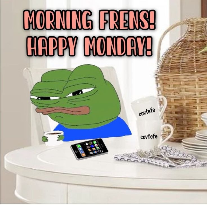 A meme featuring a sleepy-looking Pepe the Frog at a coffee table, with text 'MORNING FRENS! HAPPY MONDAY!' and coffee cups labeled 'covfefe' alongside a smartphone.
