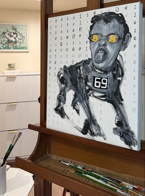 A black and white painting of a figure with yellow eyes and the number '69' on its chest, painted with binary numbers as the background, displayed on a wooden easel with paintbrushes nearby.