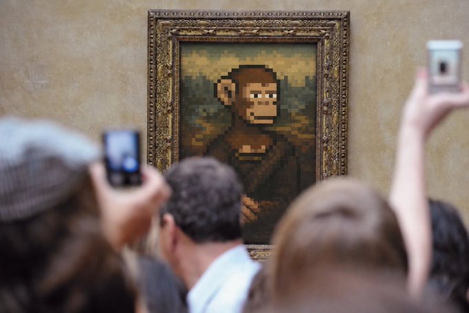 A crowd of onlookers raises their phones to photograph a framed painting of a pixelated monkey, evoking the iconic Bored Ape NFT imagery tied to the "Ape" collection minting on OpenSea. The scene humorously reimagines the digital NFT drop as a traditional museum unveiling, blending classic art presentation with crypto culture.