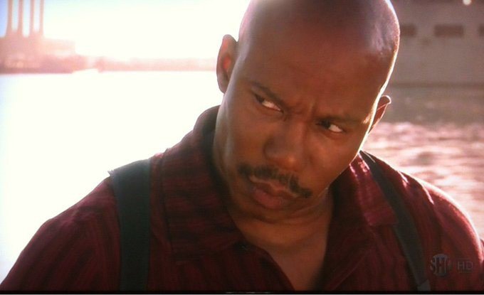 A serious-looking bald Black man in a red shirt glares downward suspiciously near a waterfront, with a "SHOWTIME HD" watermark visible, his skeptical expression mirroring the post's accusatory tone aimed at users who only seek engagement for collaborations rather than supporting regular content.