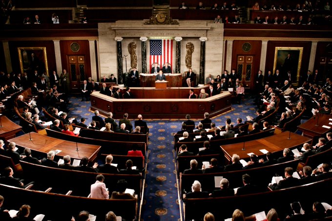 A wide-angle view of a joint session of the United States Congress in session at the U.S. Capitol, with the Speaker presiding from the rostrum beneath an American flag and surrounded by members seated in the chamber.
