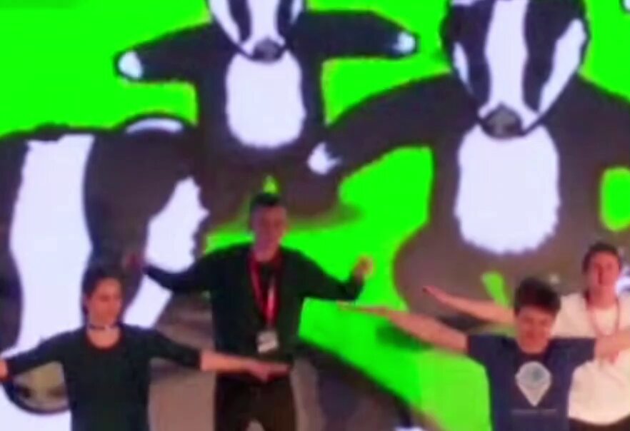 The image features a group of people standing next to each other with their arms outstretched as if they are dancing or performing some sort of act. The background includes a green wall adorned with two cartoon cow characters, one black and white and the other brown and white. The caption reads "Who has the best dance moves: 1. CEO of NVIDIA ( @nvidia ) 2. Founder of @VitalikButerin ( @bgarlinghouse ) or 3. CEO of @Ripple BRAD GARLINGHOUSE ( @bgarlinghouse )!".