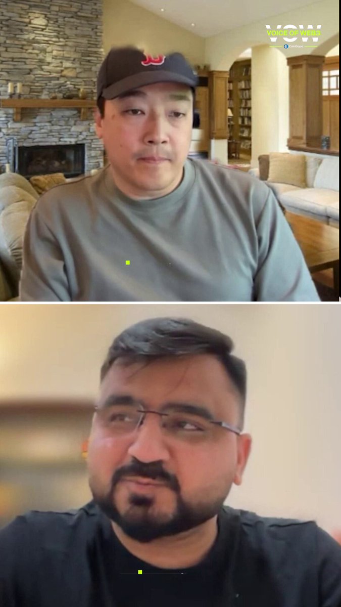 The image shows two men sitting next to each other, both wearing glasses. They are engaged in a conversation or video call with the same person being shown from both perspectives. The man on the left side of the frame appears to be wearing a hat, while the man on the right side has his back turned towards the camera.