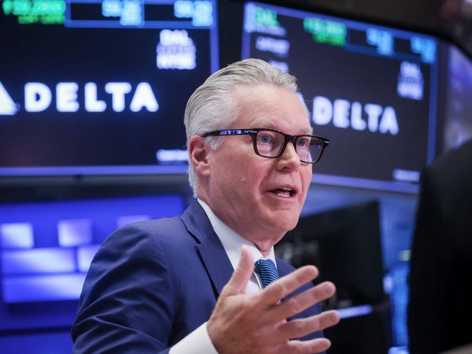 Delta Air Lines CEO Ed Bastian is shown speaking during an interview on the floor of the New York Stock Exchange, with Delta branding and stock ticker displays visible in the background. The "dump Delta" context suggests this image accompanies commentary urging investors to sell or short Delta stock.