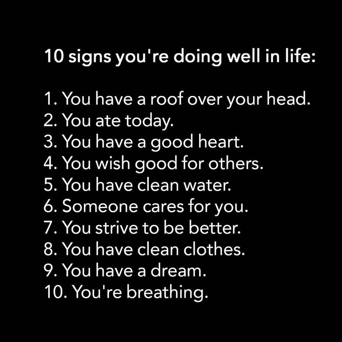 A black-background text post listing '10 signs you're doing well in life,' including having a roof, food, a good heart, clean water, someone who cares, dreams, and being alive to breathe.