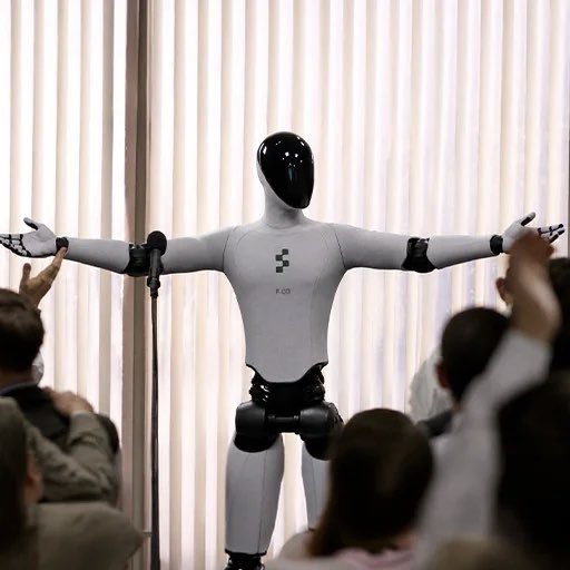 A humanoid robot stands center stage with outstretched arms before a cheering crowd, seemingly evoking the bold, futuristic hype behind an investor's enthusiastic $6.5M bet on ticker "BOT," which corresponds to Bittensor's TAO token. The image visually reinforces the post's crypto-promotional tone comparing AI/blockchain momentum to the trajectory of figures like Michael Saylor and Tom Lee.