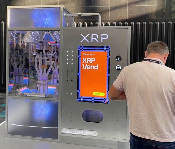 A man using an 'XRP Vend' cryptocurrency vending machine at the Consensus 2024 event.