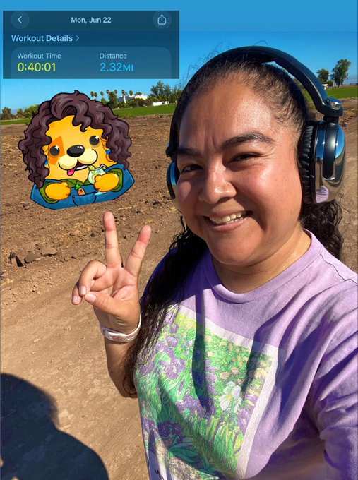 The image features a woman wearing headphones, smiling for the camera while holding up her hand with two fingers raised in a peace sign. The caption of the photo reads "Day 1 / 30 of my new health journey. Today its day one and I'm here for it!! Ready to come energized and start my day!!! Happy #RoninMondaySelfie @KindCreator @AxieArtGallery @AxieSelfie @KanstarWorld". The image seems to be promoting a fitness or wellness program, as the woman is wearing headphones while exercising.