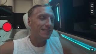 A man in a white tank top sits inside a vehicle with bright blue ambient lighting, filming himself for a YouTube video titled "5_N2EIMY1Ds" in which he declares "enough is enough" about Bitcoin's price action.