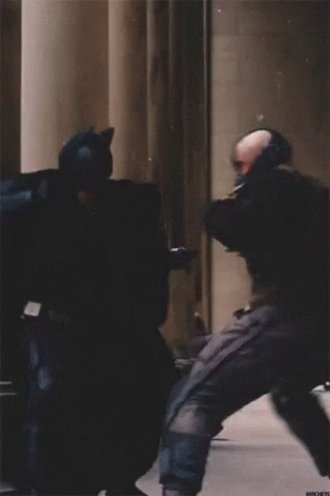 The image shows two men dressed as Batman, with one man wearing a cape and holding a baton while another man has his fist raised. They are standing close together against a backdrop of columns, suggesting that they might be in an indoor setting like a movie set or a theater. The caption reads "Never selling", which could be related to the theme of the Batman movie or simply a random statement made by someone who saw the image.