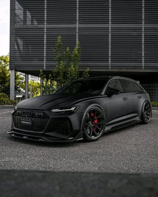 The image features a black Audi R6 sports car parked outside of a building with large windows. The car has a shiny black finish that makes it stand out against the backdrop. The car's design and color make it an interesting subject for a meme, as it is not something commonly seen in everyday life. The post about @FIH_USD1 also adds to this interest by tying the car into the world of meme currency or stablecoins.