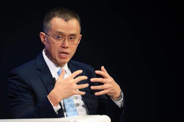 A bespectacled man in a dark suit and blue tie gestures with both hands while speaking against a black backdrop, captured mid-discussion.

The image appears to depict Changpeng Zhao (CZ), founder of Binance, as referenced in the accompanying post discussing his views on Hyperliquid's potential entry into the U.S. market as a positive signal for the crypto industry.