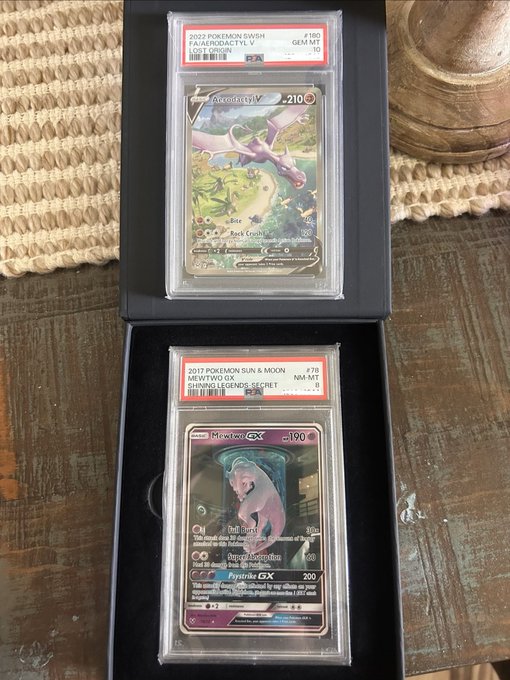 Two graded PSA 10 Pokémon cards are displayed in a case: a 2022 Fa/Aerodactyl V and a 2017 Shining Mewtwo GX from the 'Shining Legends' set.