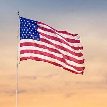 The American flag waves against a sunset sky, symbolizing the U.S. government's role in shaping crypto regulation as the SEC proposes new rules that could ease institutional investment in digital assets.