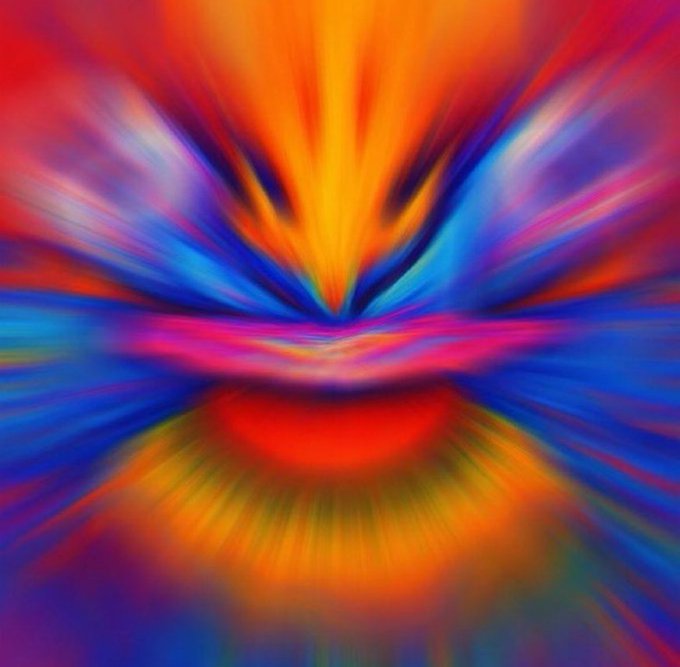 Abstract colorful digital artwork featuring an explosive burst of orange, yellow, blue, and pink hues radiating from the center.