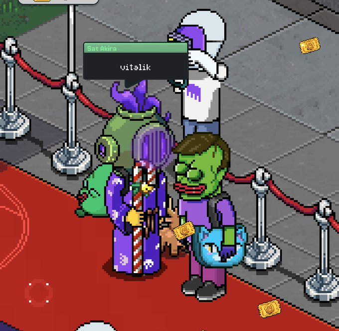 A pixel-art style mobile game screenshot featuring a zombie-like character with green skin and red lips on a red carpet, with a speech bubble reading 'Sat Akira' and 'vitalik'. Other quirky characters including a green monster and a purple alien stand nearby in a VIP roped-off area.
