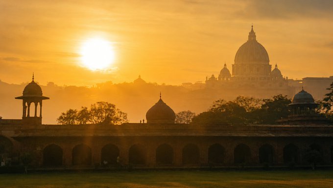 A scenic sunset view of a domed building complex silhouetted against an orange sky, likely showing Mughal architecture.