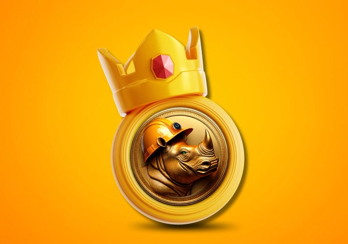 A 3D-rendered golden coin featuring a rhinoceros wearing a hard hat sits against a yellow background, topped with a golden crown set with a red gem.