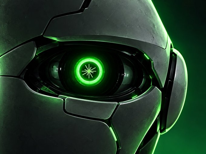 A close-up of a metallic robotic or armored face featuring a glowing green circular eye with a starburst pattern, set against a dark green background.