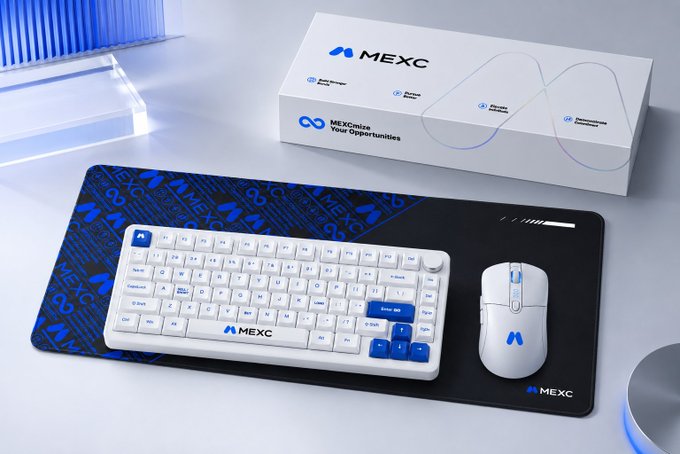 A white and blue mechanical keyboard and mouse set sits on a black desk mat, displayed with its "MEXC" branded packaging box.