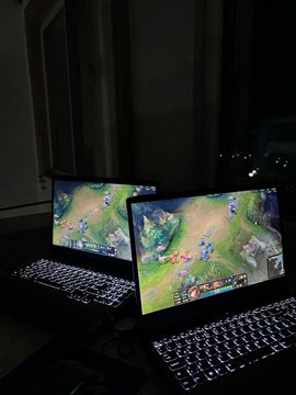 Two laptops display a League of Legends game screen, visually representing the esports niche where this trader achieved a $24,216 profit in three months on Polymarket.