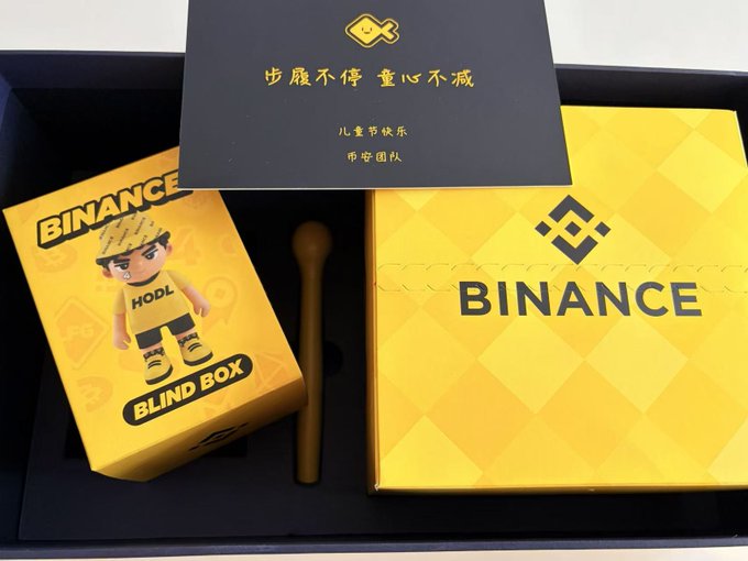 The image features two boxes - one yellow and one black, both containing binance cryptocurrency trading cards. The yellow box has a boy figurine inside, while the black box contains a card with the word "binance" written on it. The boxes are placed next to each other, creating an interesting visual contrast between the bright colors of the boxes and the monochrome appearance of the cards within them.

The post includes text that reads: "Happy Children's Day! Everyone only sees how high I've climbed and how far I've gone, but only Binance @ binancezh treats me like a kid, giving me a whole day of child' s joy~ Today I suddenly feel that it'S pretty nice to be a little childish sometimes, you can spend half the day. You can spend half the day." The image seems to be promoting a fun and lighthearted way for children to learn about cryptocurrency trading cards while enjoying themselves.
