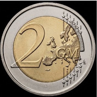 A close-up photograph of a 2 Euro coin, clearly showing the "2" denomination and a map of Europe, set against a black background.