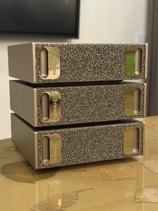 Three stacked NVIDIA-branded server units, each consuming approximately 250W for a combined peak of ~750W, visually reinforcing the post's claim that high-performance AI compute is becoming inexpensive enough to run multiple in a home setting.